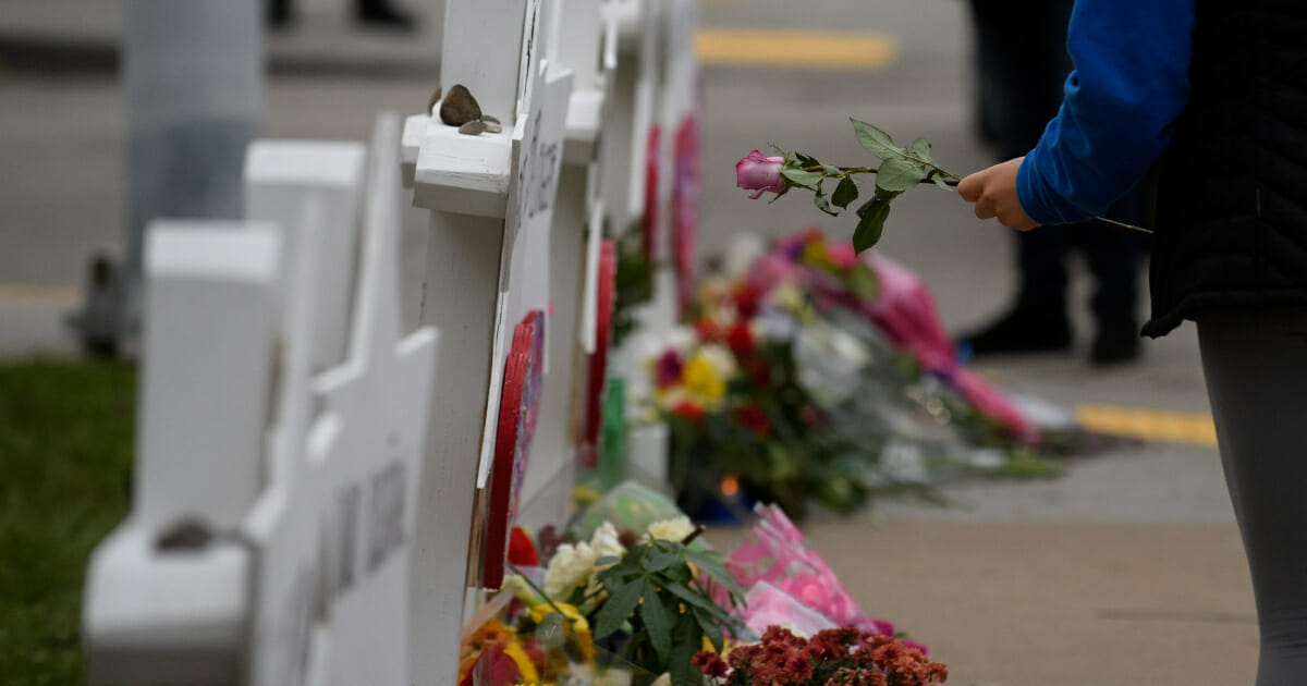 A mourner lays flowers at a memorial for victims of the mass shooting that killed 11 people and wounded six at the Tree of Life synagogue on Oct. 29, 2018 in Pittsburgh, Pennsylvania.