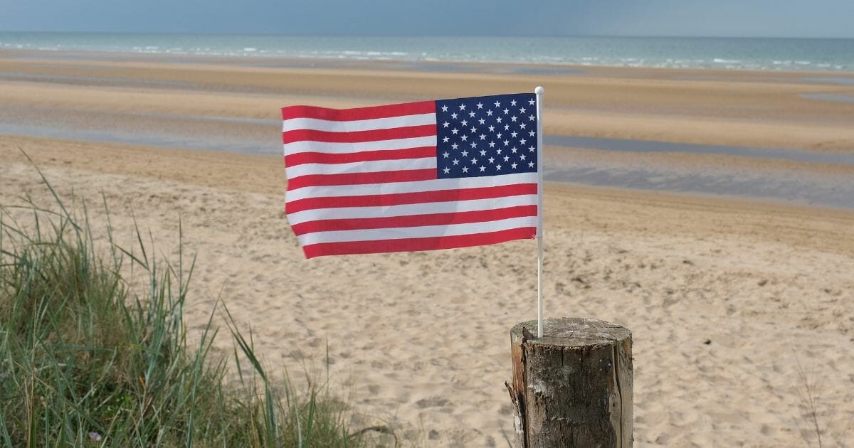 An American flag flies on Omaha Beach in Normandy on the 75th anniversary of the World War II Allied D-Day invasion on June 6, 2019, near Colleville-Sur-Mer, France.