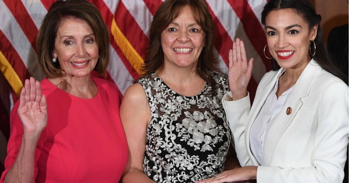 Speaker of the House Nancy Pelosi, left, performs a ceremonial swearing-in for Rep. Alexandria Ocasio-Cortez, right