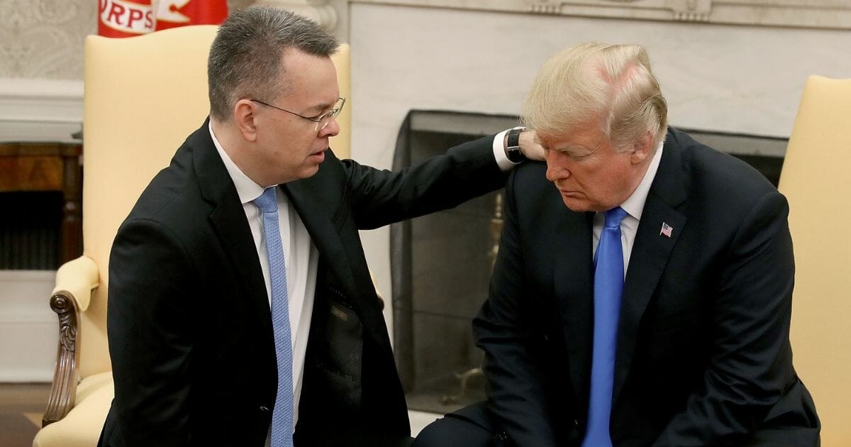 Pastor Andrew Brunson, left, prays with President Donald Trump in the Oval Office.
