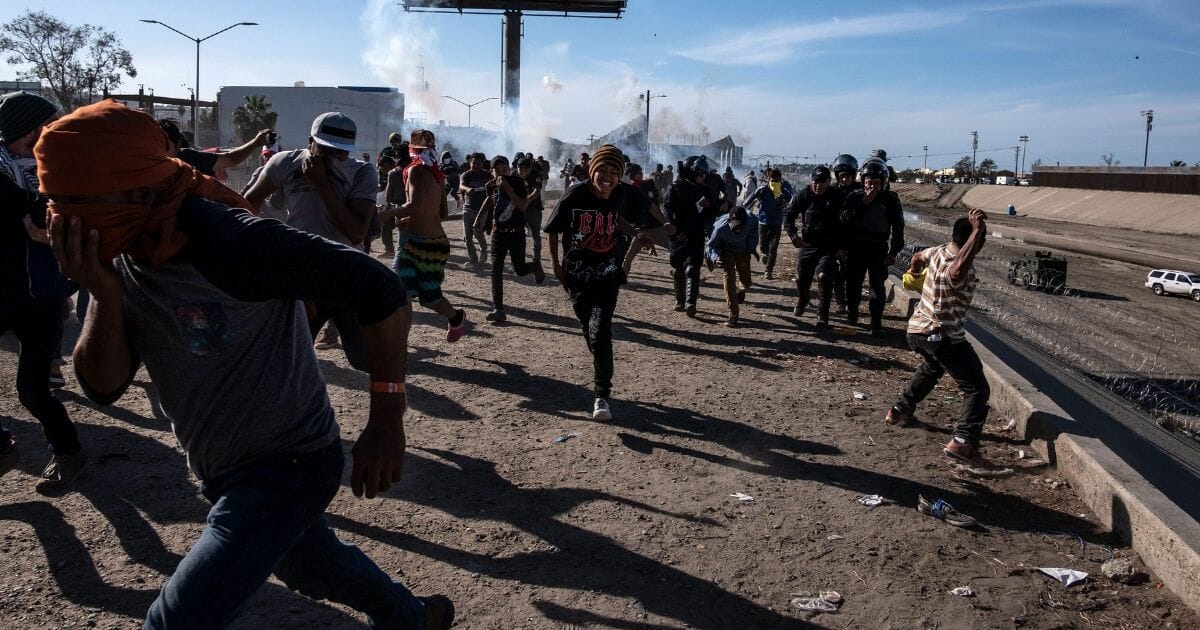 Illegal immigrants flee tear gas fired by U.S. Border Patrol agents in a November file photo.