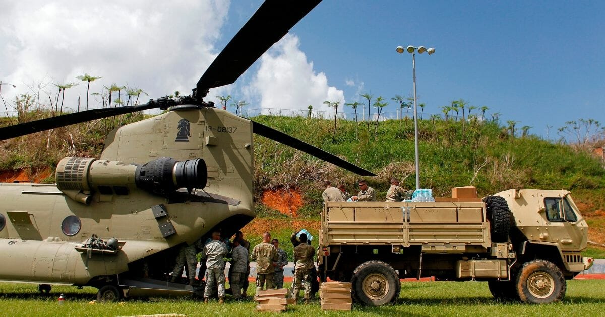 Military helicopter and personnel distribute hurricane relief supplies in Puerto Rico in October 2017.