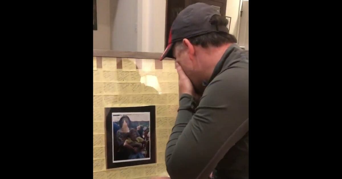 The dad stares at the gift, crying.