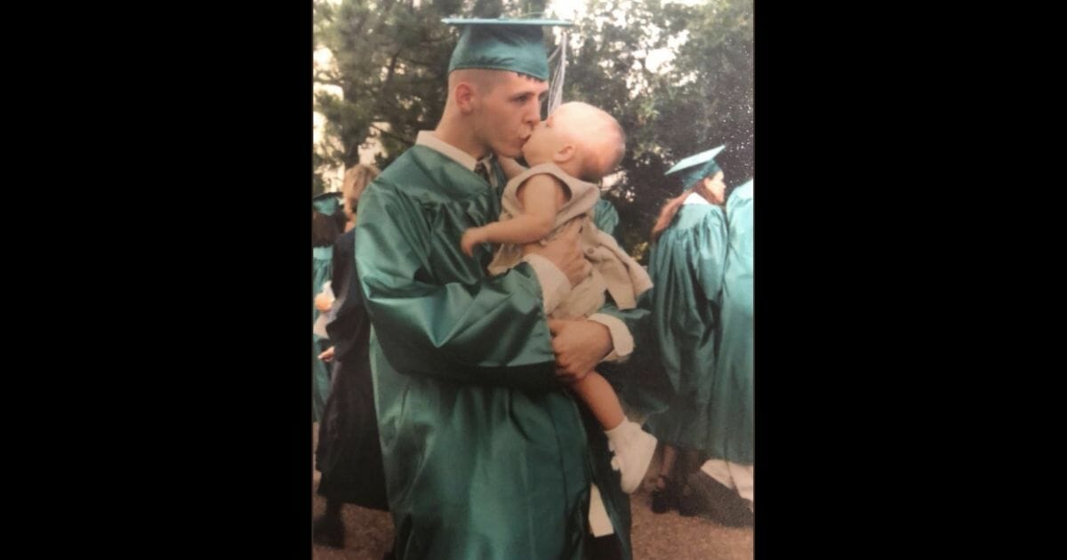 graduating dad kissing baby daughter