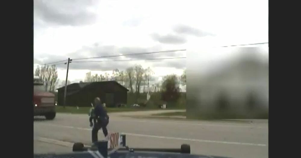 Cop carries toddler out of the road.