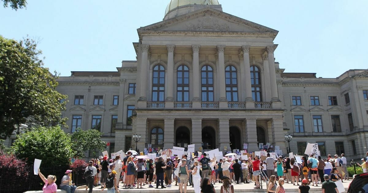 Abortion rights advocates rally in front of the Georgia State Capitol to protest new restrictions on abortions that have been passed in May 21, 2019.