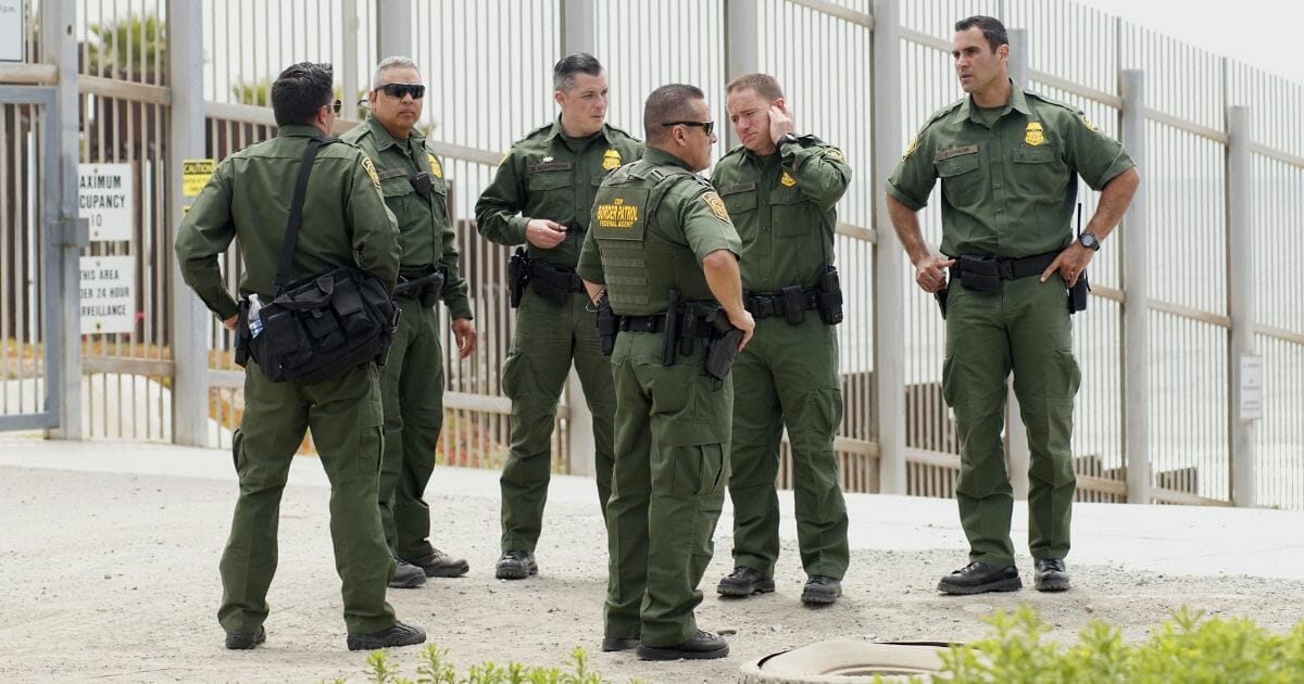 Border Patrol agents patrol the area near where Attorney General Jeff Sessions addresses the media during a press conference at Border Field State Park on May 7, 2018.