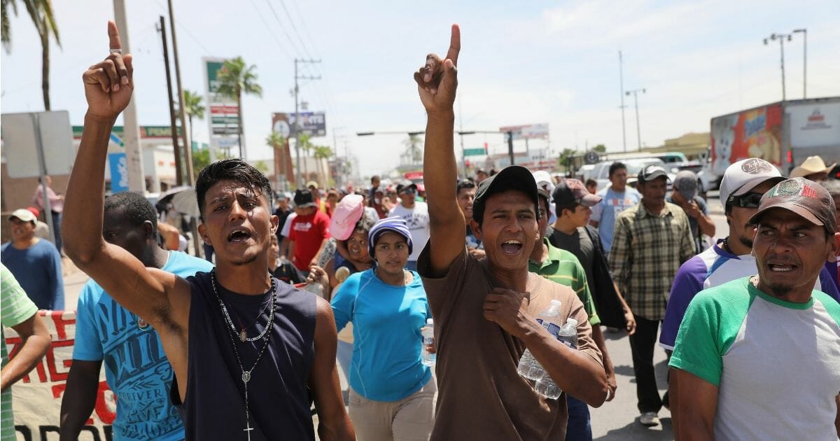 Central American immigrants, part of an immigrant "caravan," march in protest against U.S. President Donald Trump.