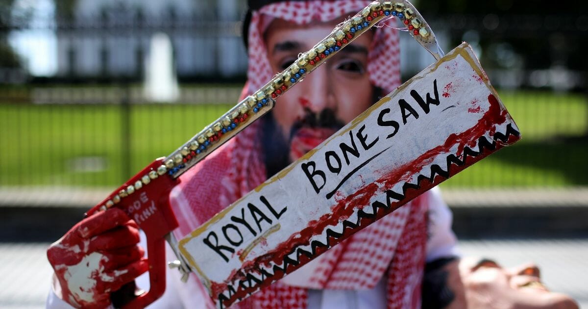 A protester dressed as Saudi Arabian crown prince Mohammad bin Salman, demonstrates with members of the group Code Pink outside the White House in the wake of the disappearance of Saudi Arabian journalist Jamal Khashoggi October 19, 2018.