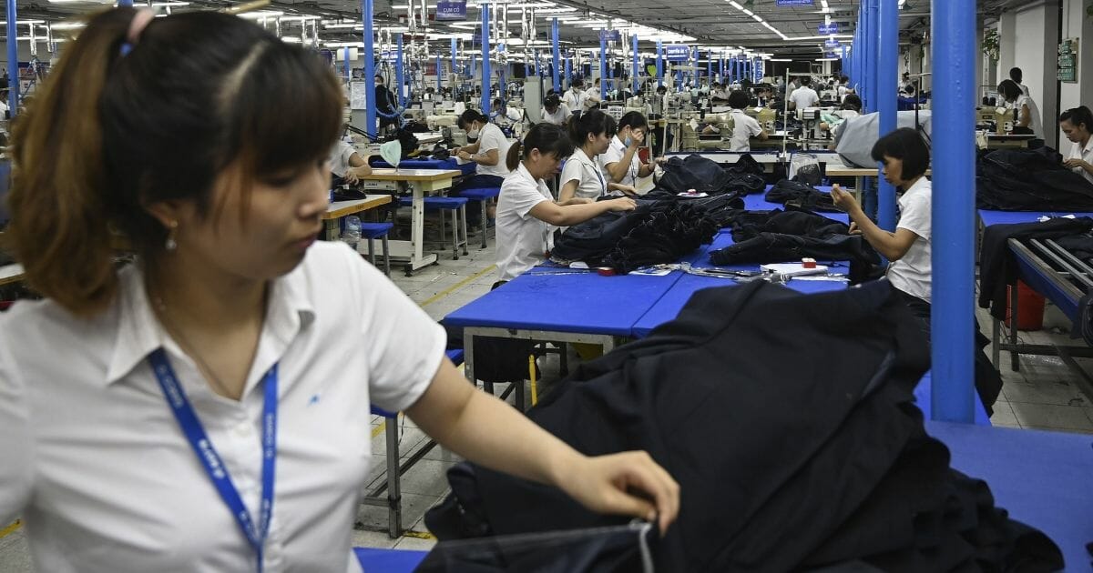 This photograph taken on May 24, 2019, shows workers making men's suits in a factory in Hanoi.
