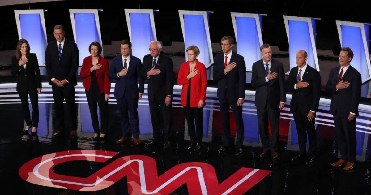 The 10 candidates who participated in Tuesday night's Democratic debate stand for the national anthem in Detroit, Mich.