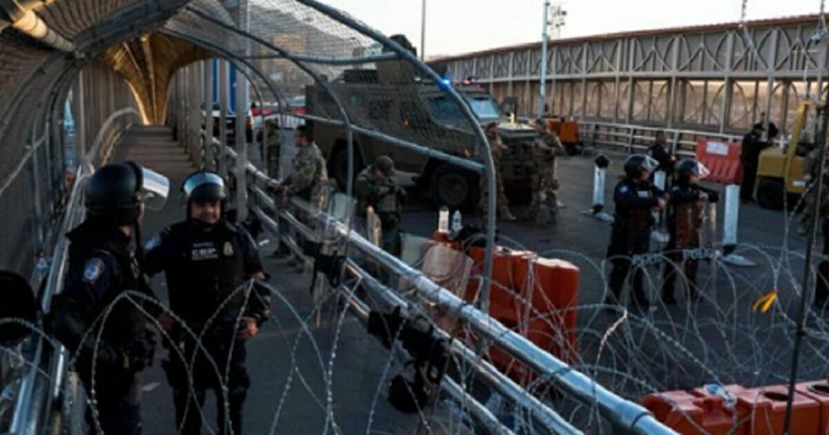 Customs and Border Protection agents wear riot gear and deploy concertina wire in El Paso on Monday.