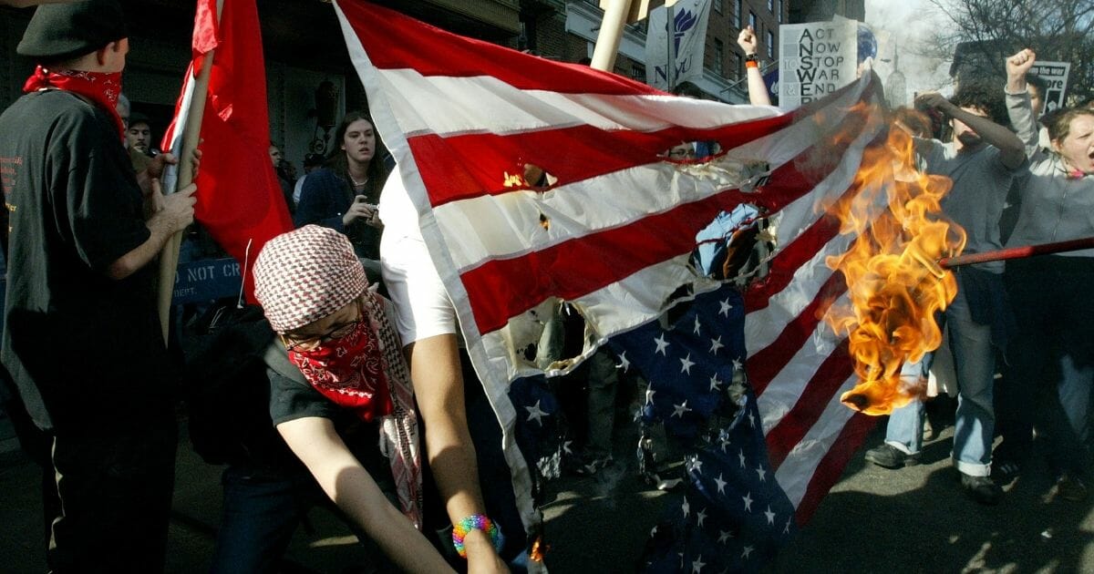 Anti-war protesters burn an American flag during a demonstration at Washington Square Park on March 22, 2003, in New York City.