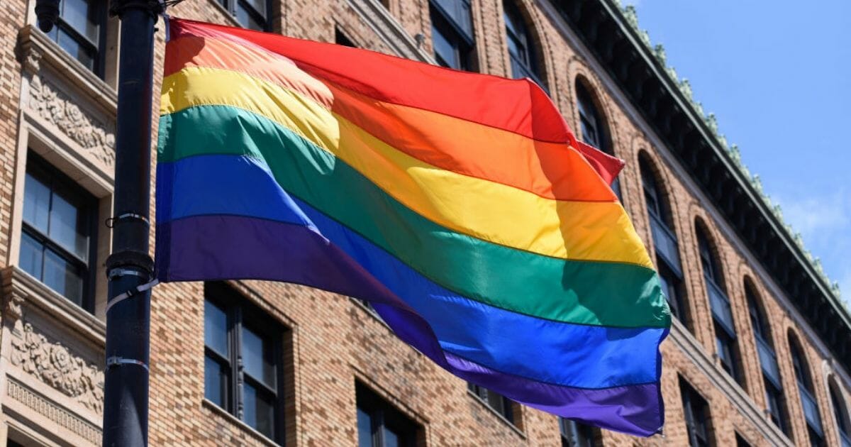 A gay pride flag flies over a parade on June 30, 2019, in San Francisco, Calif.