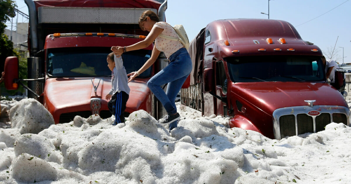 A woman and a child walk on hail in Guadalajara, Mexico, on June 30, 2019.