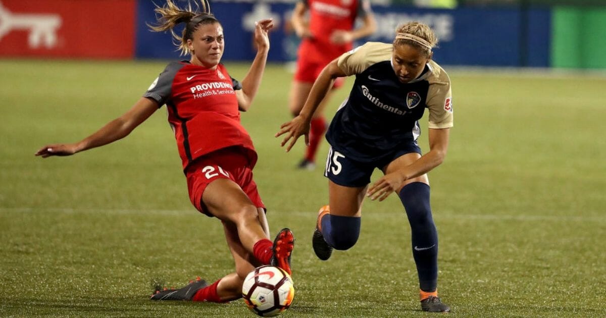 Portland's Kelli Hubly, left, goes for the ball against Jaelene Hinkle of the North Carolina Courage on May 30, 2018, in Portland, Ore.
