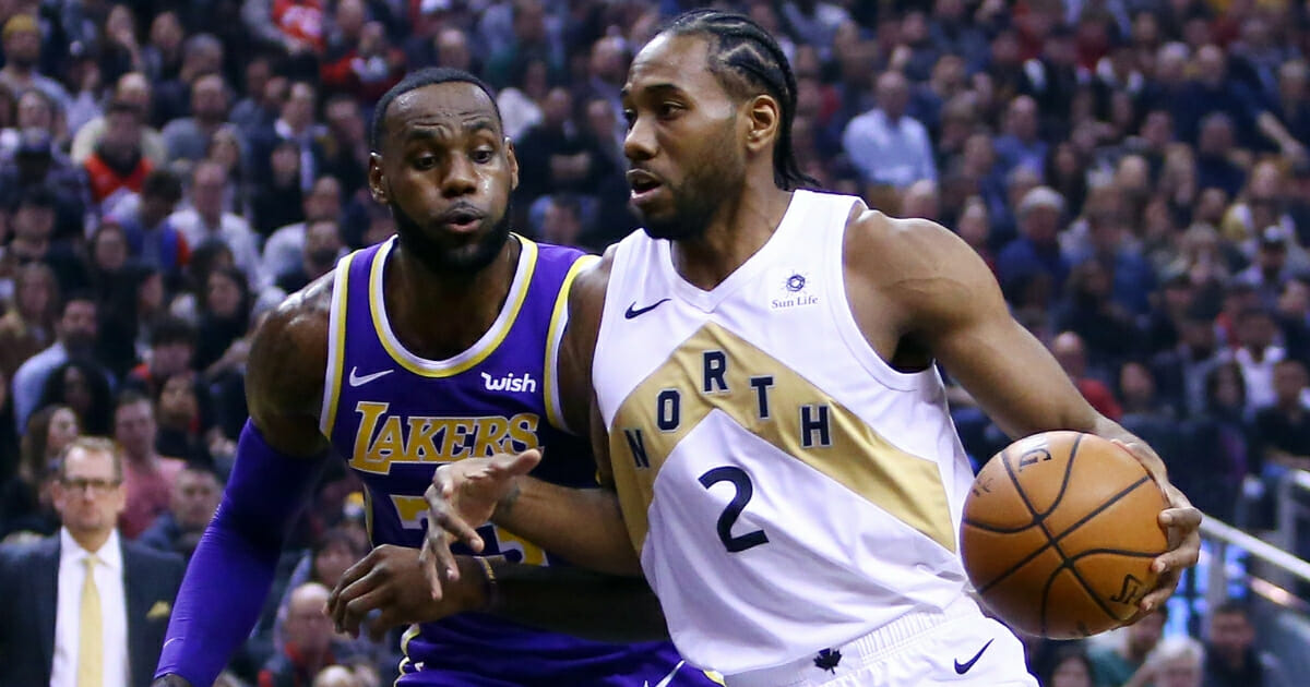 Kawhi Leonard of the Toronto Raptors dribbles as LeBron James of the Los Angeles Lakers defends.