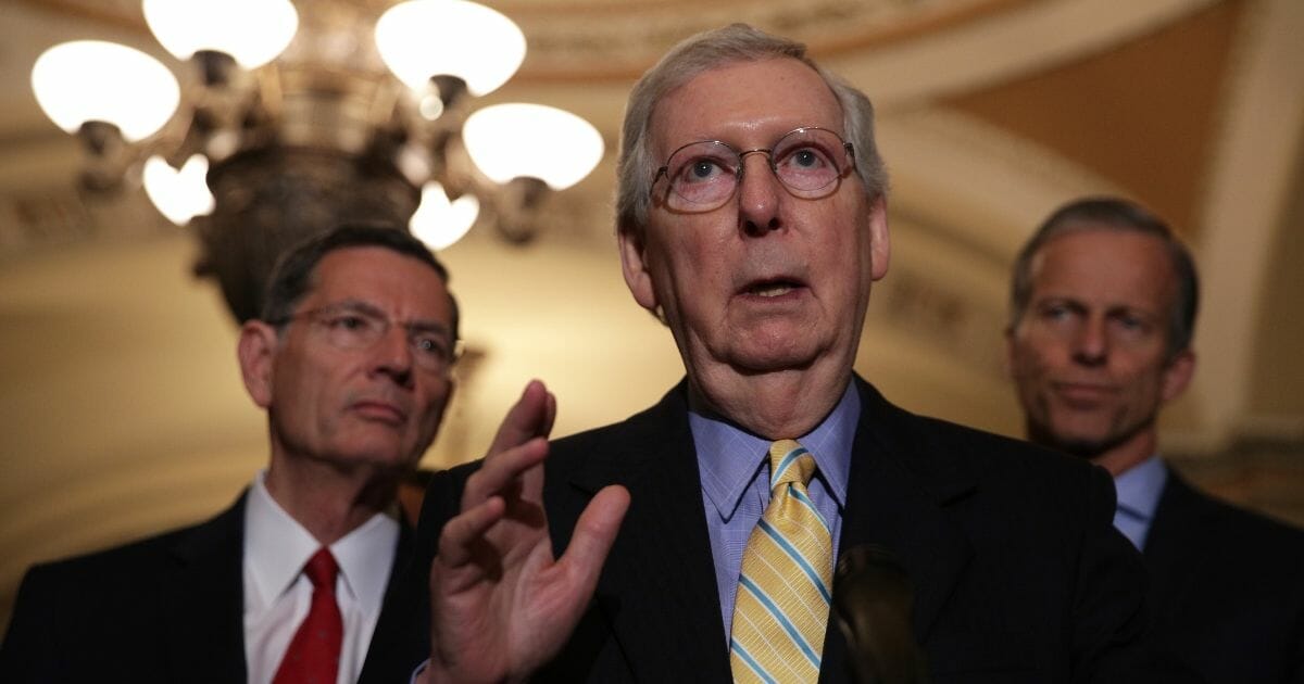 Senate Majority Leader Mitch McConnell (R-KY) (Center) speaks as Sen. John Barrasso (R-WY) (Left) and Senate Majority Whip John Thune (R-SD) (Right) listen during a news briefing after the weekly Senate Republican policy luncheon June 11, 2019, at the U.S. Capitol in Washington, D.C.