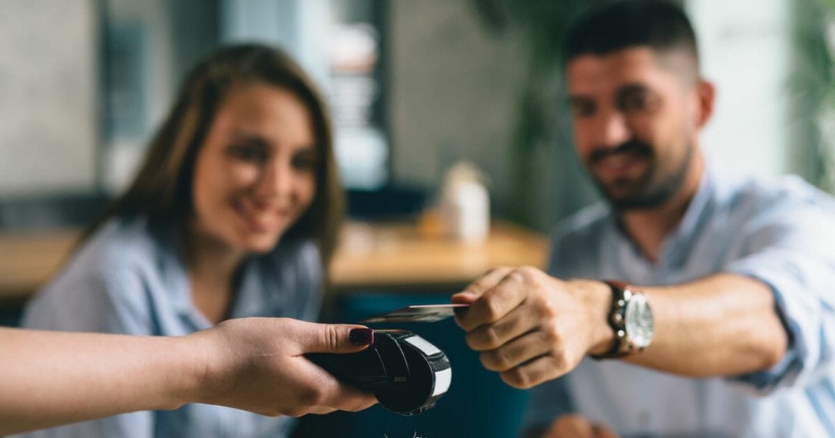 A restaurant patron pays a server.