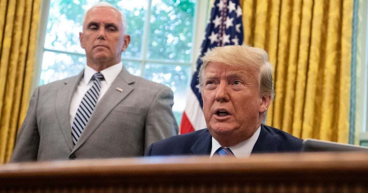 President Donald Trump speaks to reporters as Vice President Mike Pence observes in the Oval Office in Washington, D.C., on July 1, 2019.
