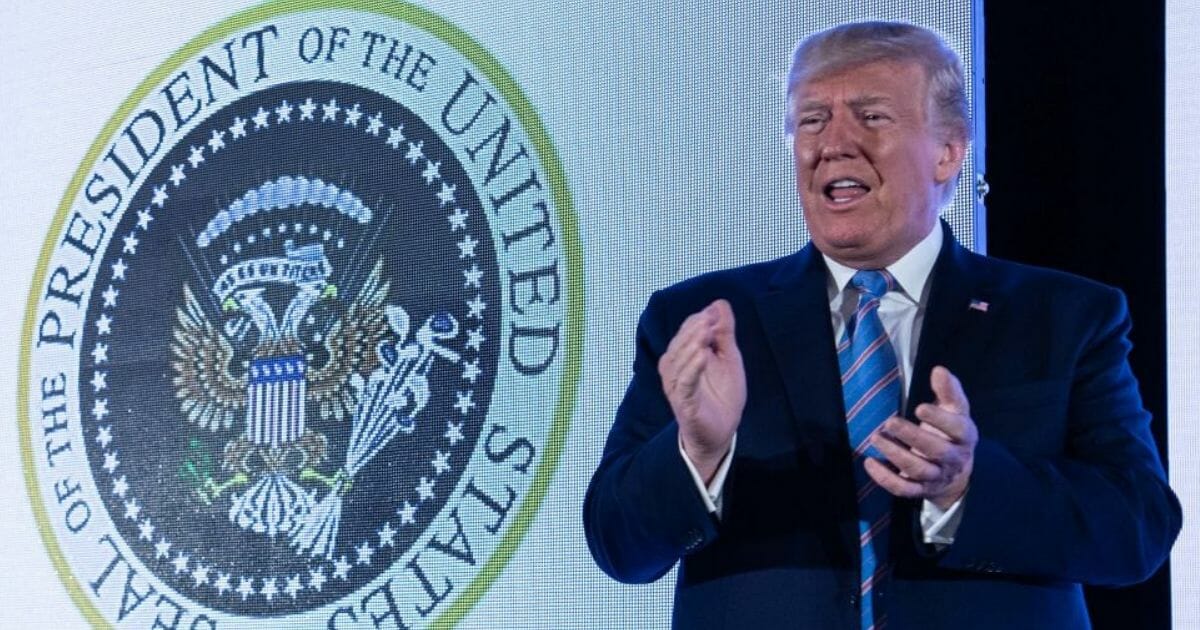 President Donald Trump stands next to an altered presidential seal as he arrives to address the Turning Point USA's Teen Student Action Summit 2019 in Washington, D.C., on July 23, 2019.
