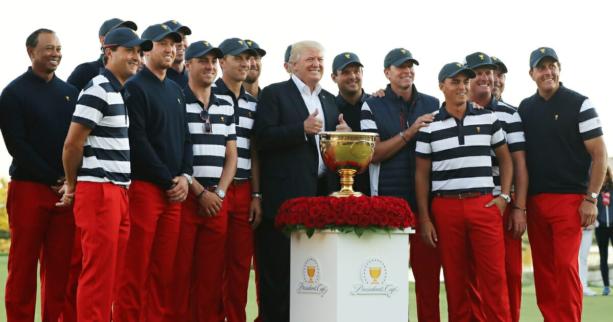 President Donald Trump poses with the U.S. team after it won the Presidents Cup at Liberty National Golf Club in Jersey City, New Jersey.