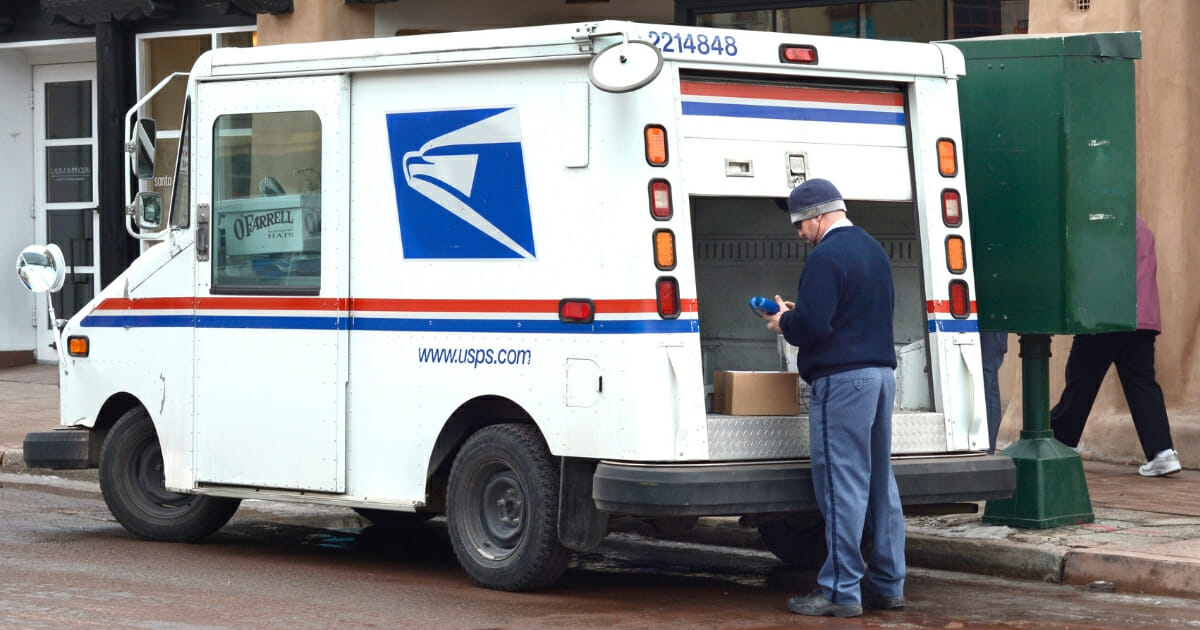A U.S. postal worker delivers mail and packages in Santa Fe, New Mexico
