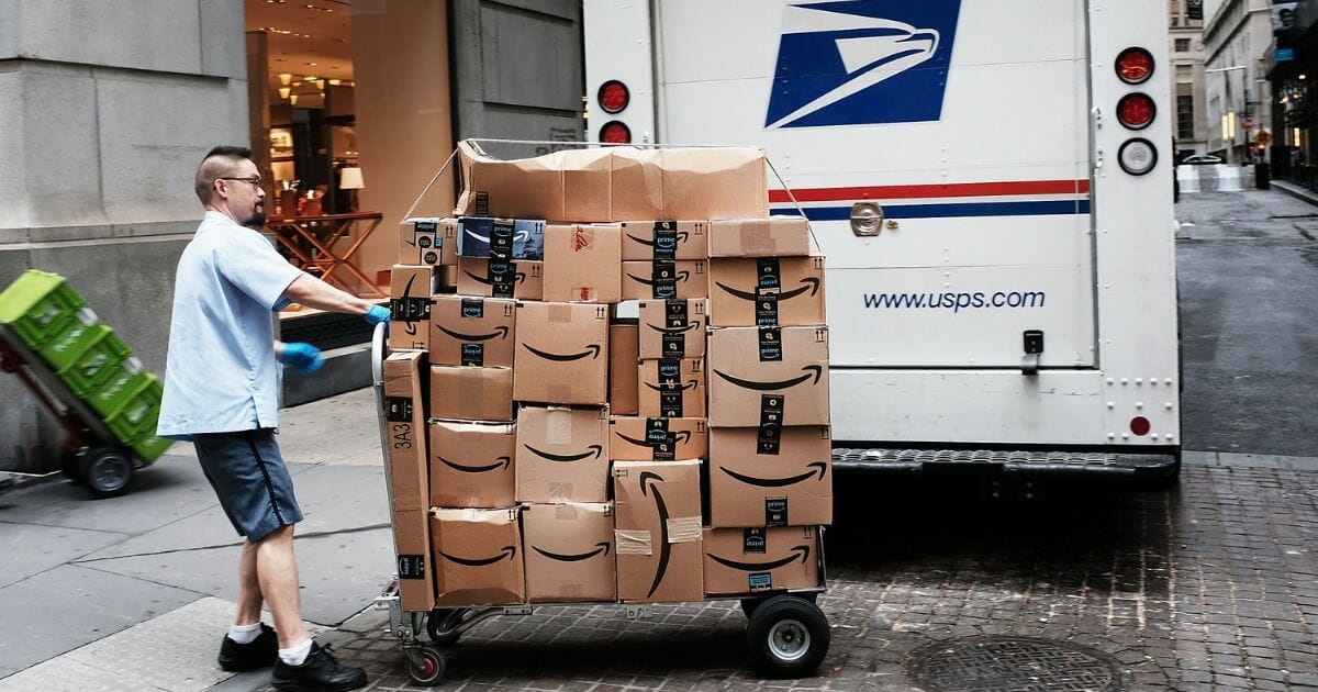 A US Postal worker delivers Amazon boxes outside of the New York Stock Exchange.