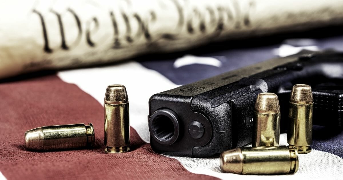 Gun with flag and copy of the Constitution.