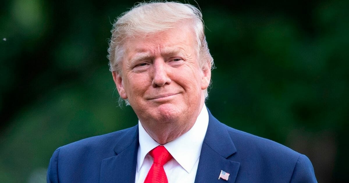 President Donald Trump waves to the media after returning to the White House on Sunday.