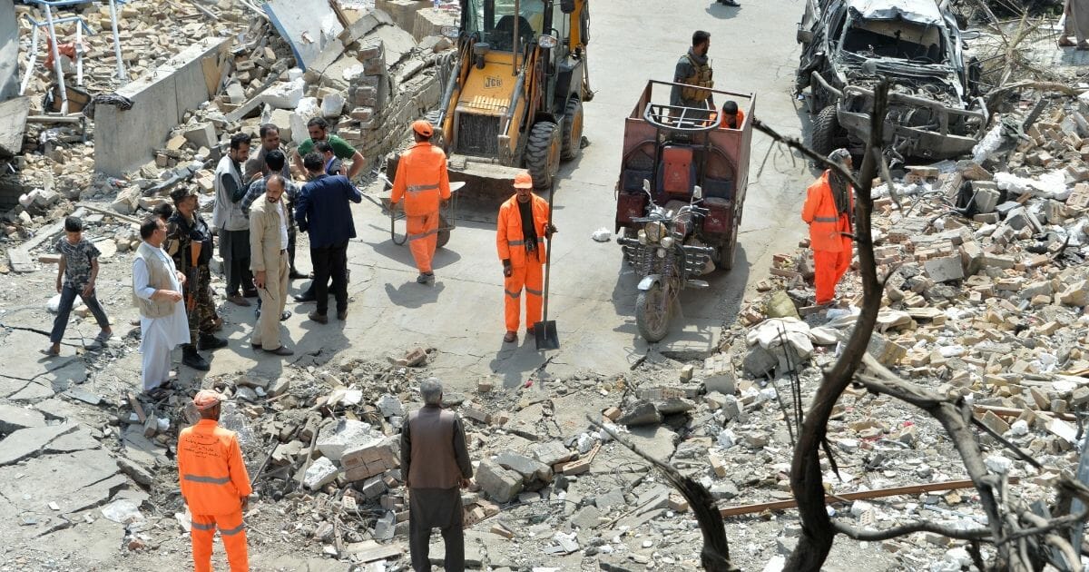 Afghan security forces and municipality workers gather at the site of an attack in Kabul on Monday, a day after a deadly assault targeting a political campaign office killed 20 and wounded 30.