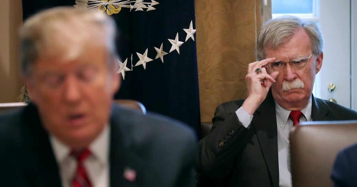 National Security Adviser John Bolton listens to U.S. President Donald Trump talk to reporters during a meeting of his cabinet in the Cabinet Room at the White House February 12, 2019