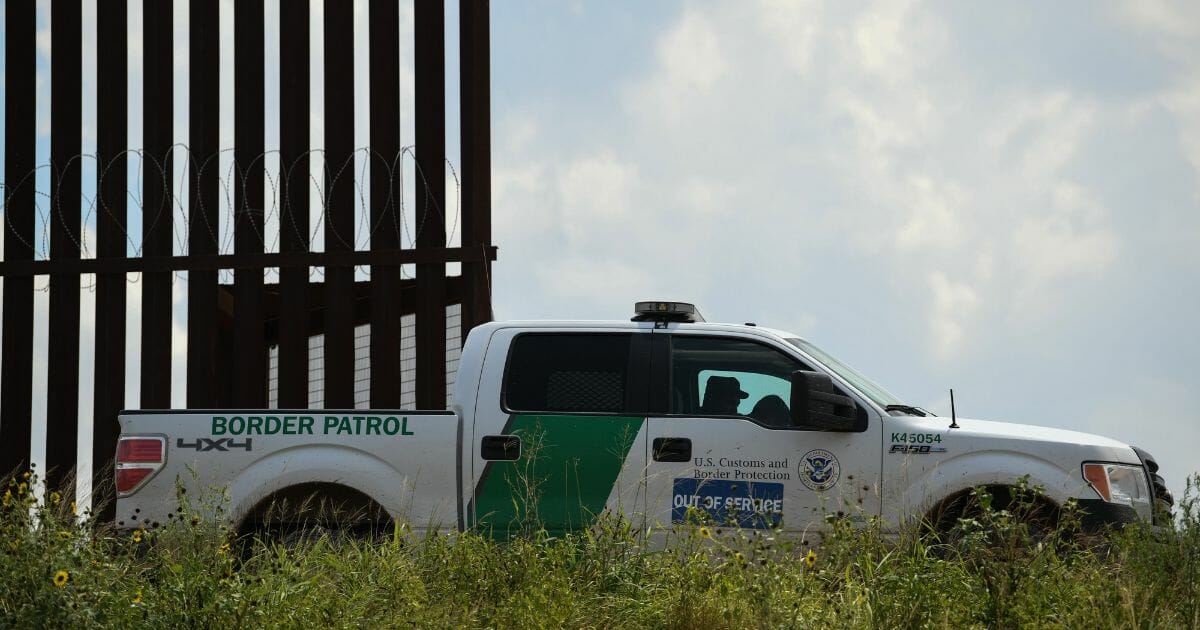A border patrol truck near a fence on the U.S.-Mexico border