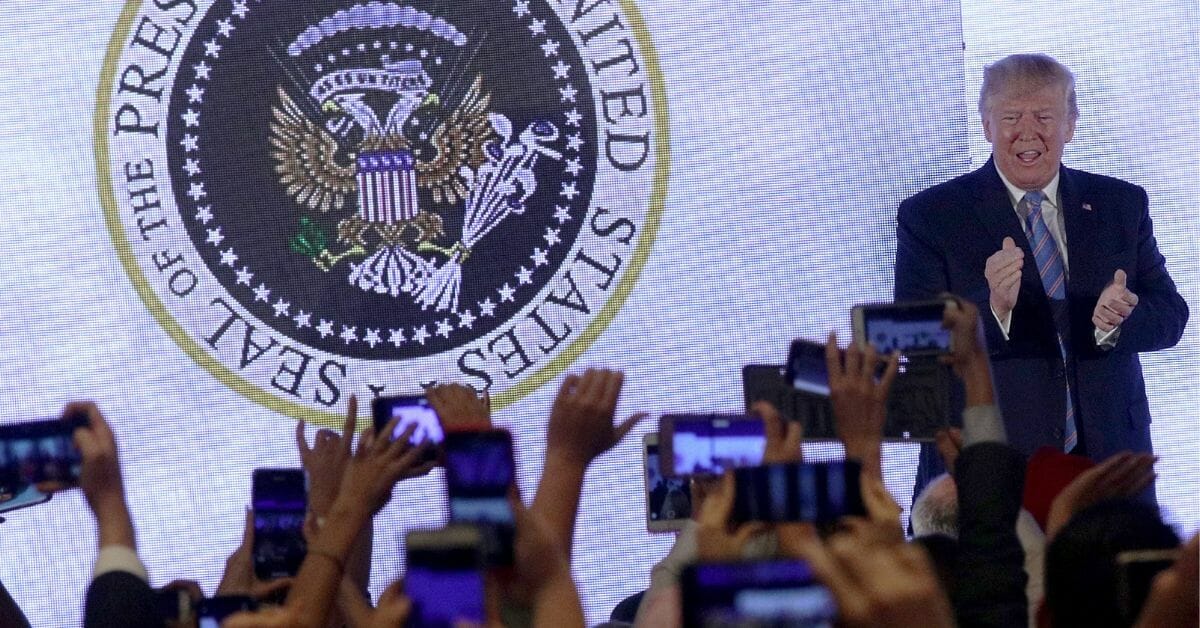 President Donald Trump applauds in front of a doctored presidential seal during the Teen Student Action Summit.