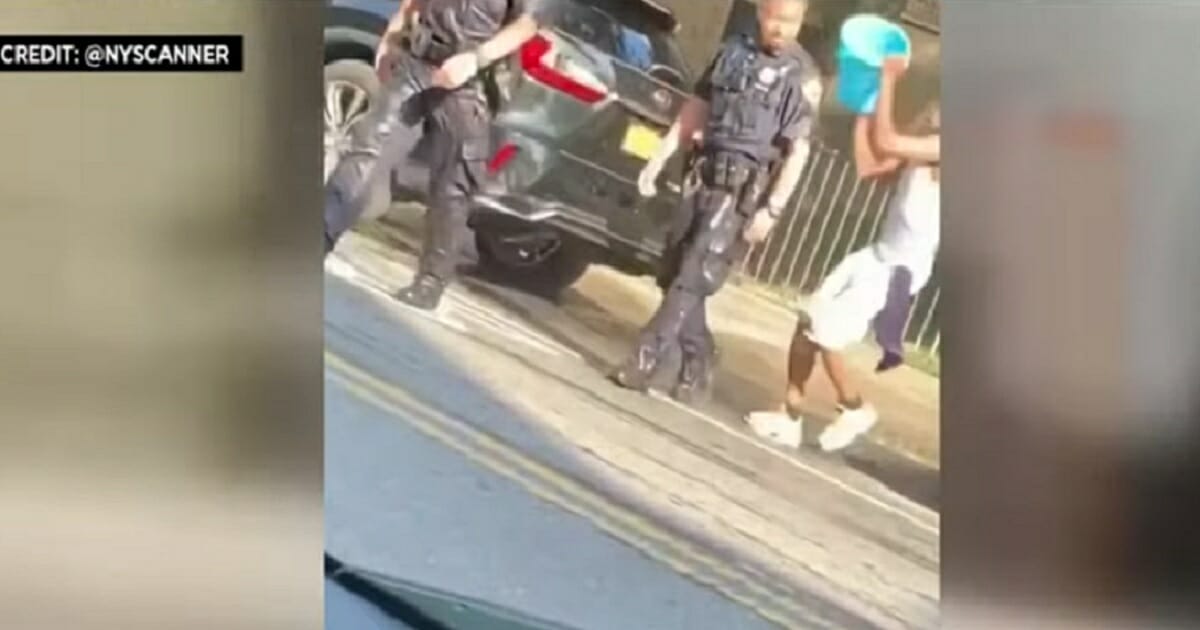 A man prepares to dump a bucket of water over a police officer's head.