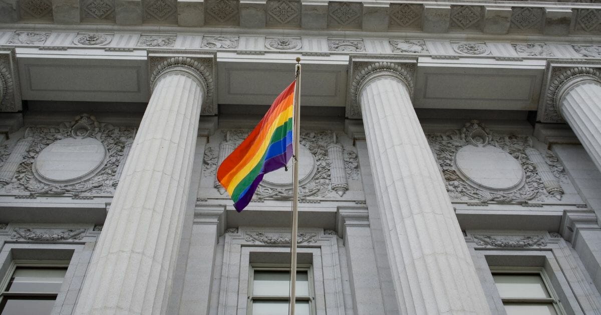 LGBT pride flag flying outside a government building.