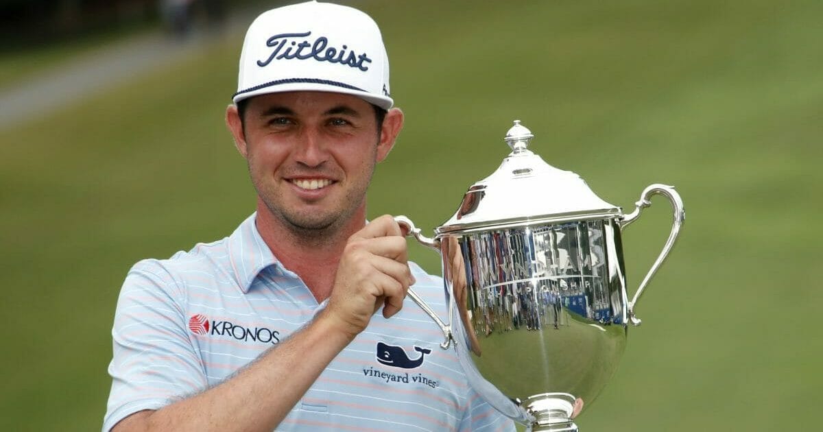 J. T. Poston holds the trophy after he won the Wyndham Championship