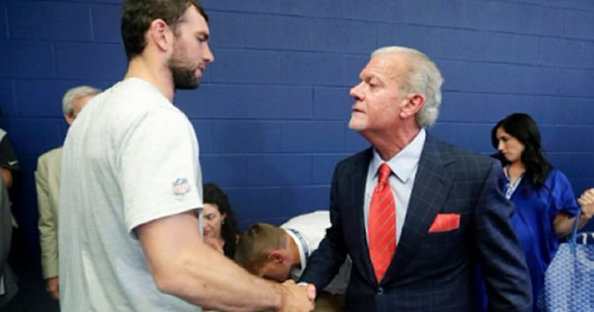 Retiring NFL quarterback Andrew Luck, left, shakes hands with Indianopolis Colts owner Jim Irsay on Saturday.