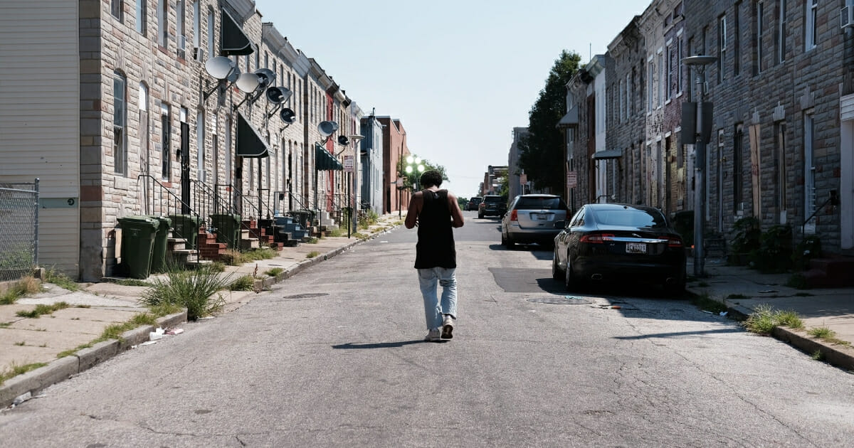 A man walks down a Baltimore street near where a person was recently murdered on July 28, 2019 in Baltimore, Maryland. While the struggling city has a number of affluent areas, it also has a stubborn crime problem and one of the highest murder rates in the nation for a city of any size.