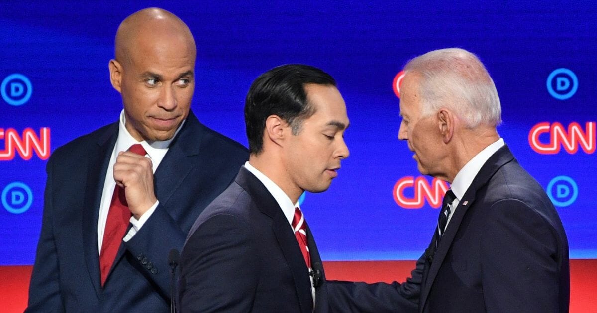 Sen. Cory Booker, former HUD Secretary Julian Castro and former Vice President Joe Biden chat during a break in the second round of the second Democratic presidential debate July 31, 2019, in Detroit, Mich.