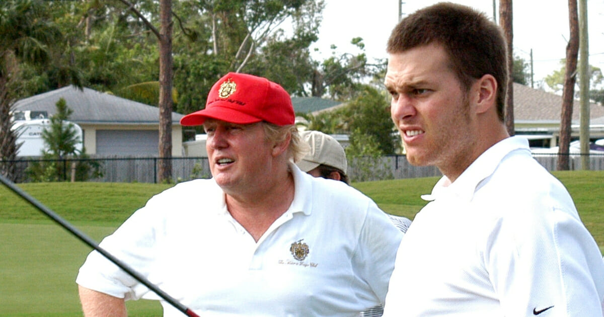 Donald Trump watches as New England Patriots quarterback Tom Brady tees off at Trump International Golf Club in Palm Beach.