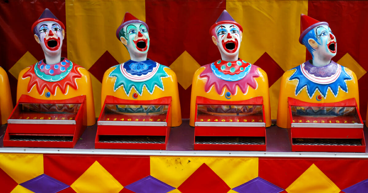 A lineup of clown figurines in a carnival game.