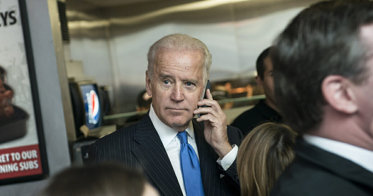 Former Vice President Joe Biden speaks on cell phone during a grand opening at Capriotti's Sandwich Shop on Nov. 21, 2013, in Washington, D.C.