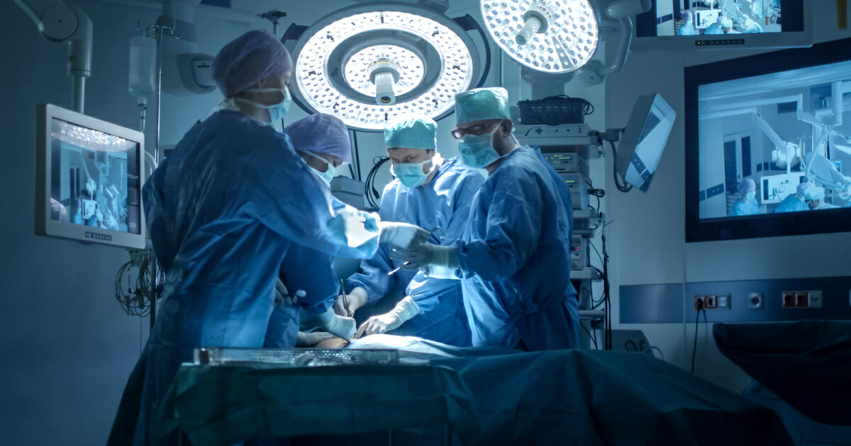 A stock photo of a medical team performing a surgical operation in a modern operating room.