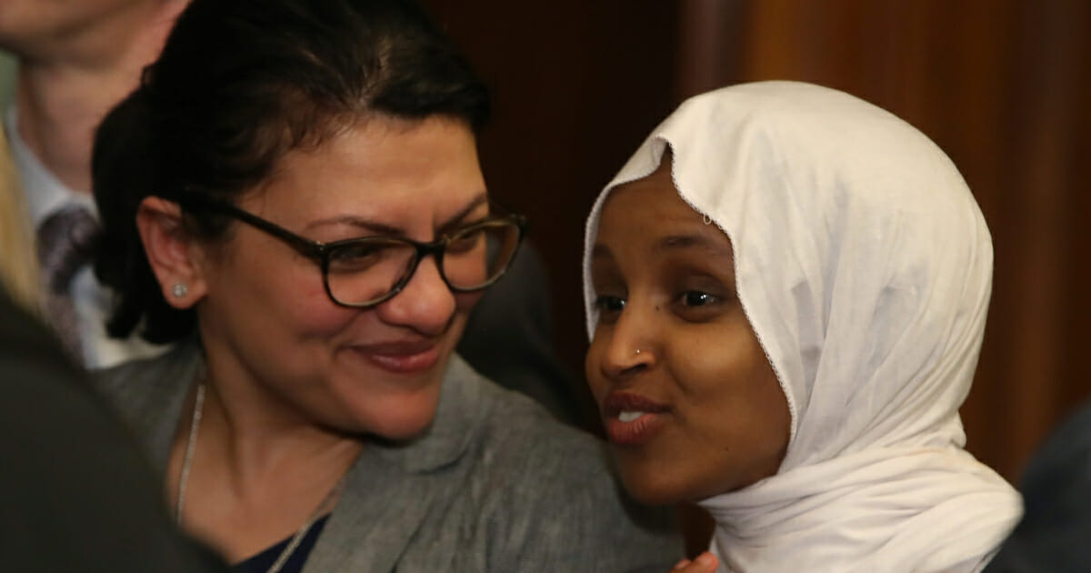 Rep. Ilhan Omar (D-MN), right, and Rep. Rashida Tlaib (D-MN) attend a news conference where House and Senate Democrats introduced the Equality Act of 2019 which would ban discrimination against lesbian, gay, bisexual and transgender people, on March 13, 2019, in Washington, D.C.