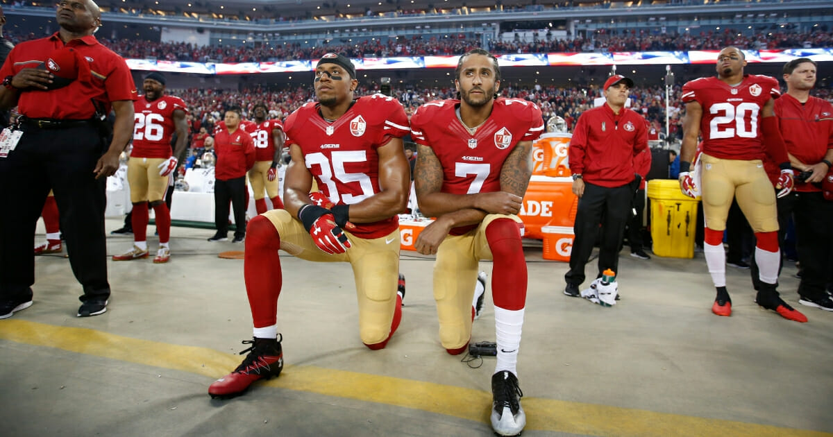 Colin Kaepernick, right, and Eric Reid of the San Francisco 49ers kneel during the national anthem.