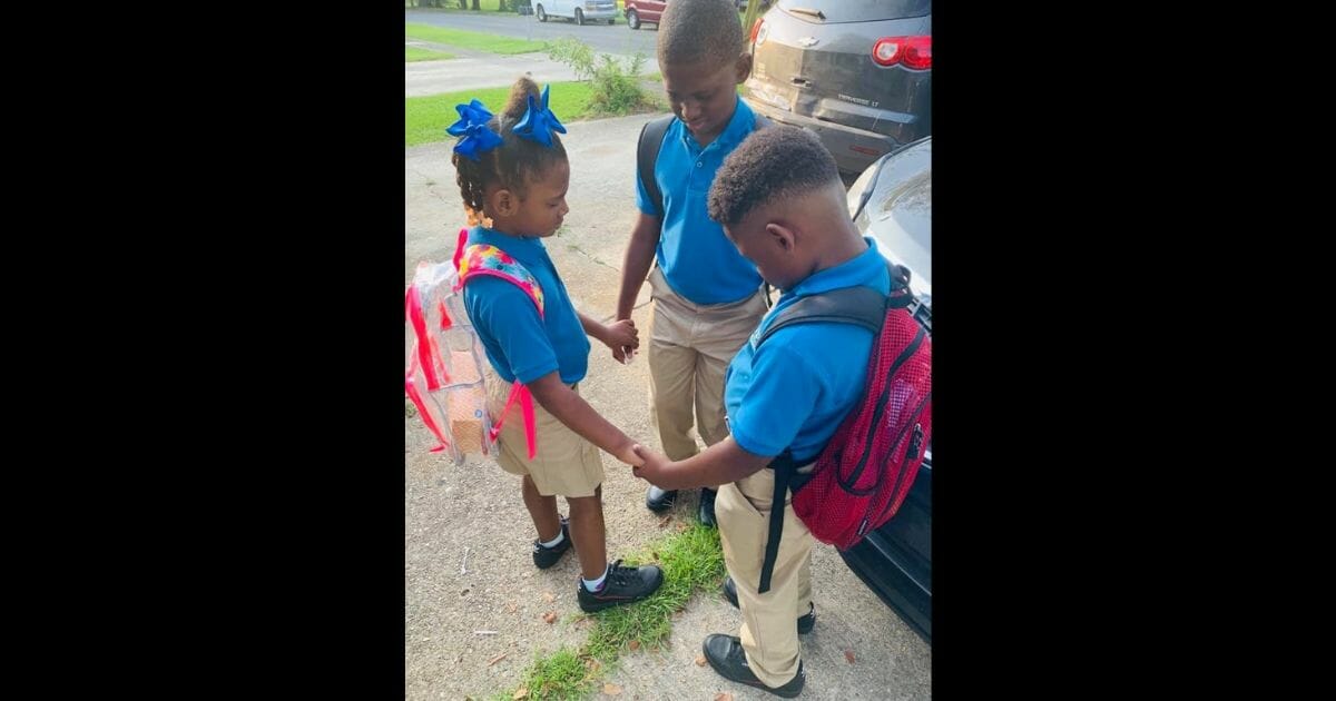 Kids pray together on the first day of school.