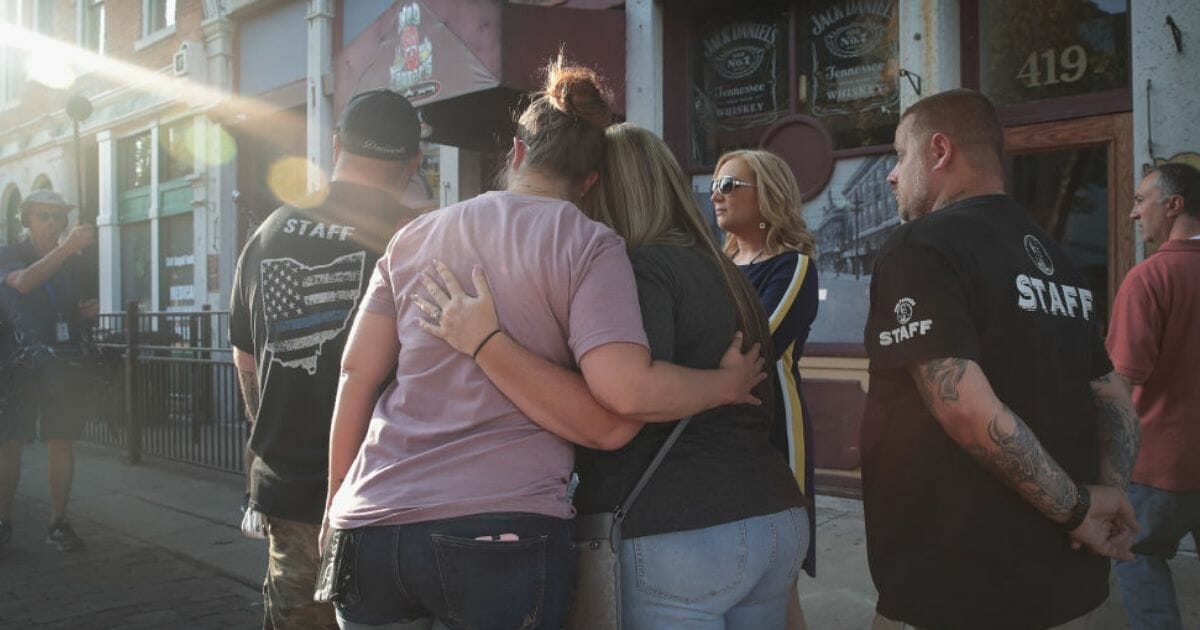 Friends, coworkers and other Dayton, Ohio, residents gather outside Ned Peppers in the Oregon District, where a lone gunman killed nine Sunday morning.