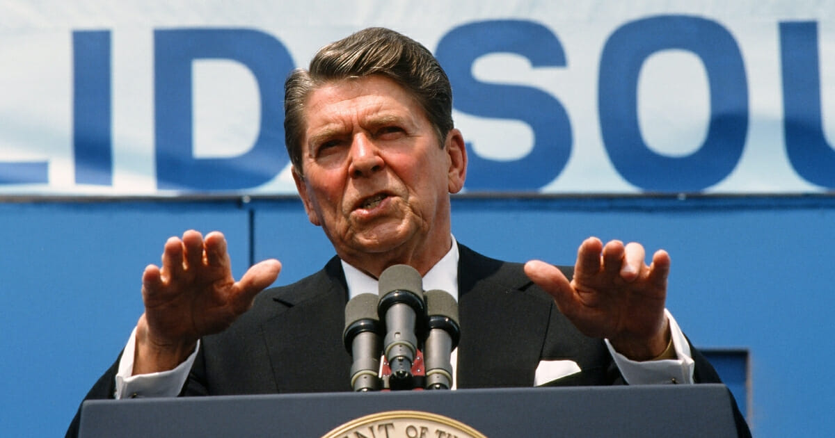 During his re-election campaign, then-President Ronald Reagan (1911 - 2004) delivers a speech under a large banner in June, 1984.