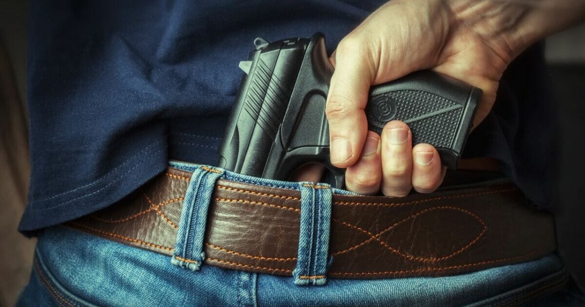 Stock photo of a man with a pistol tucked into his belt